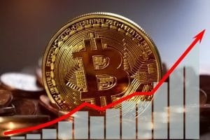 Uma moeda de Bitcoin dourada em primeiro plano, rodeada por uma pilha de outras moedas de Bitcoin. Ao fundo, um gráfico financeiro verde com uma linha de tendência e uma seta verde apontando para baixo, indicando uma queda no valor da criptomoeda. No fundo, um gráfico financeiro domina a cena, exibindo uma clara tendência de baixa. As barras do gráfico, que representam a movimentação do preço, são predominantemente verdes, indicando um período de queda. Uma seta verde vibrante e proeminente aponta para baixo, reforçando visualmente a ideia de desvalorização da moeda. O contraste entre o dourado das moedas e o verde do gráfico e da seta cria um ponto focal que direciona o olhar para a queda no valor. A iluminação de estúdio realça as texturas e os reflexos metálicos das moedas, conferindo à imagem um aspecto profissional e de alta qualidade. O fundo escuro com um padrão geométrico sutil adiciona profundidade e um toque futurista à composição.